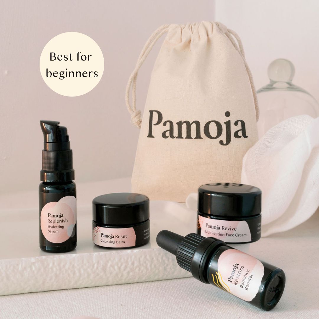 IThe Mini Experience natural skincare gift set with four mini products, organic cotton bag and cloth on neutral background.