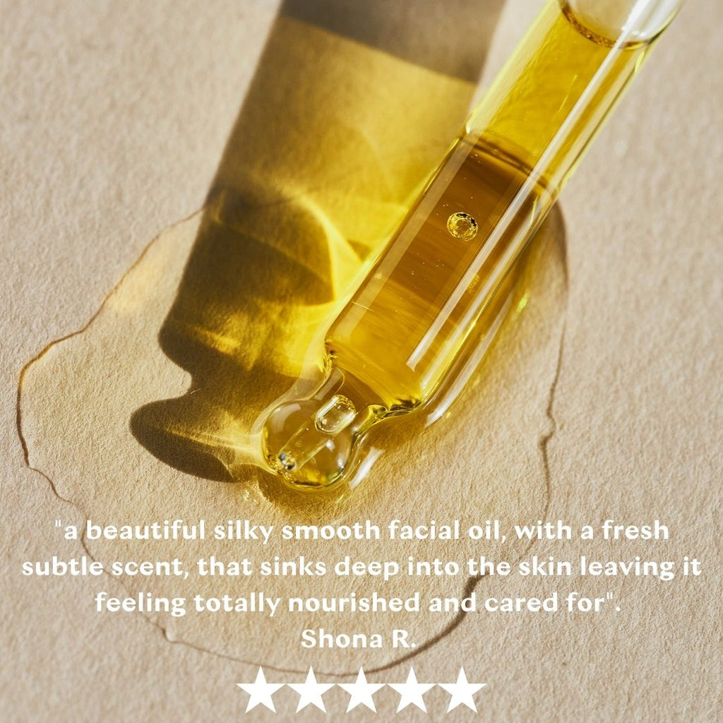 Close up of lightweight facial oil puddling on glass surface showing a customer testimonial